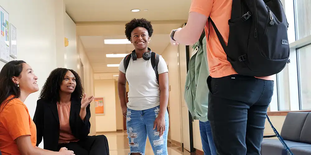 Students meeting with a staff member in the COBA building.