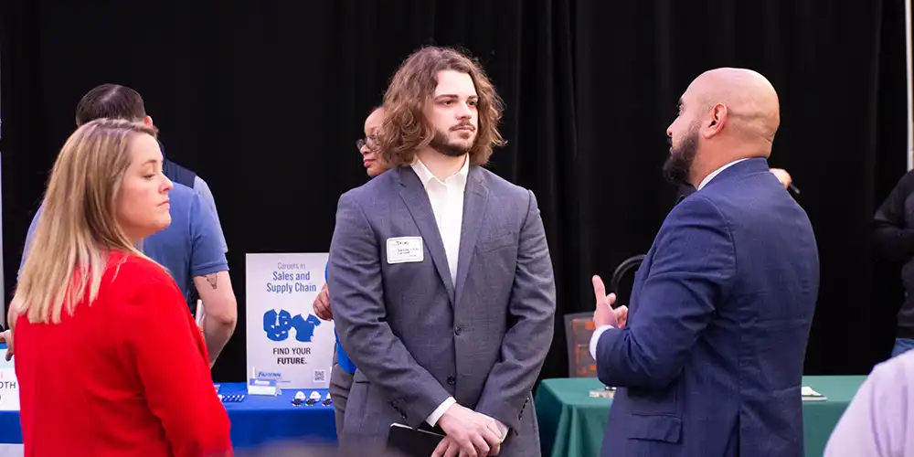 A student meeting with recruiters at an event.