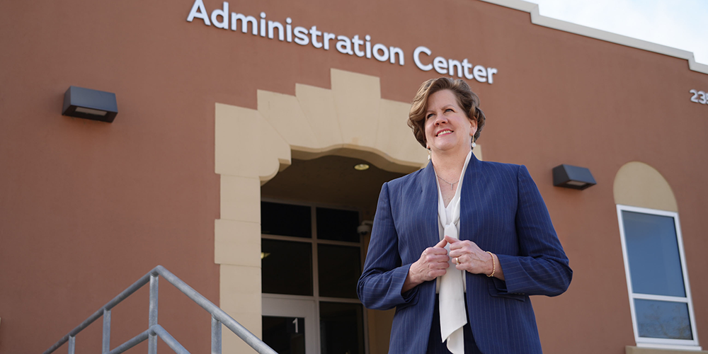 Professional woman standing in front of a brick building