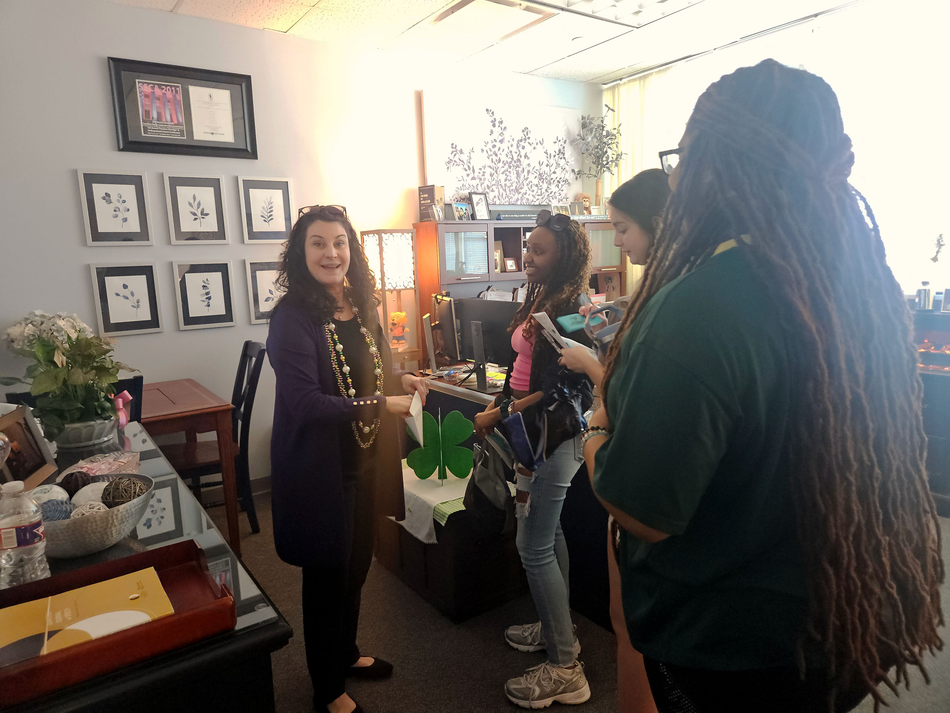 SHSU students speak with Frances Brandau, chair of Communication Studies, in her office.