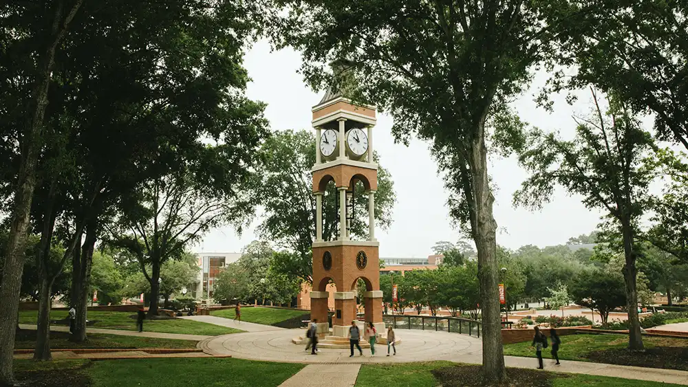 View of the clock tower with students walking. 