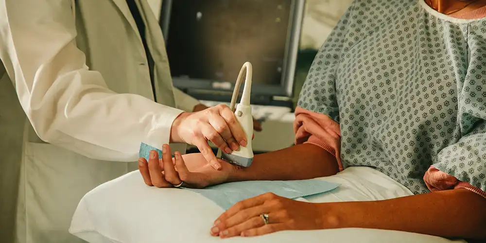 Student doing an ultrasound of a patient wrist in a simulation room