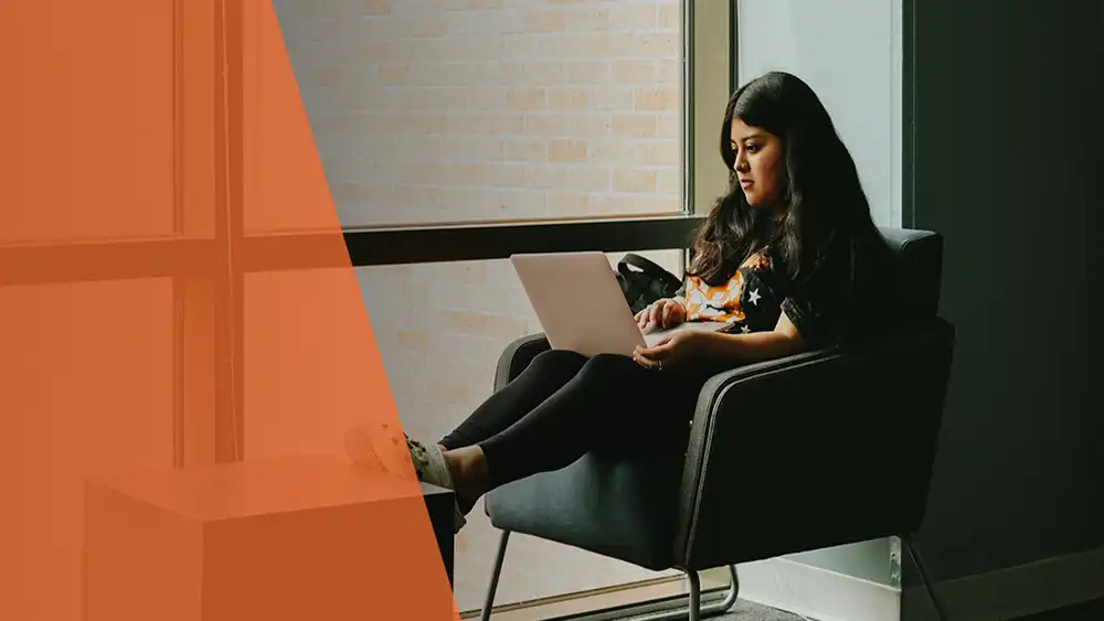 Student sitting in chair using laptop