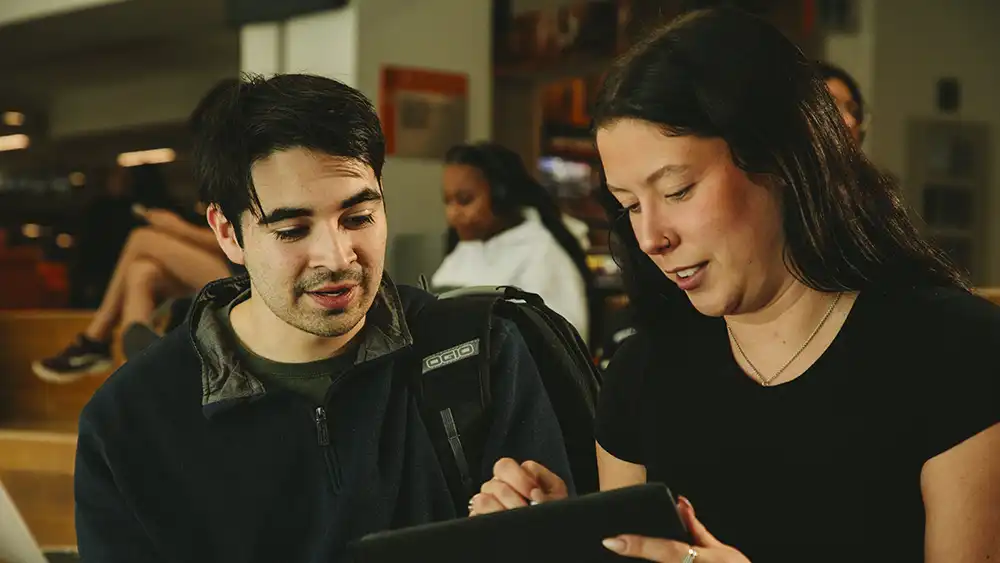 Two students looking at a tablet.