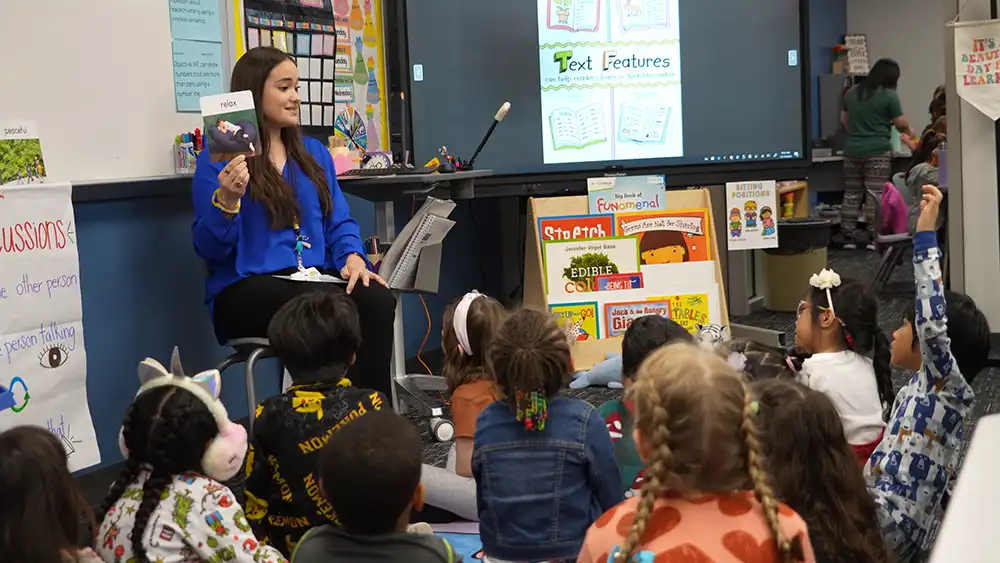 Teacher working in her classroom with young students.