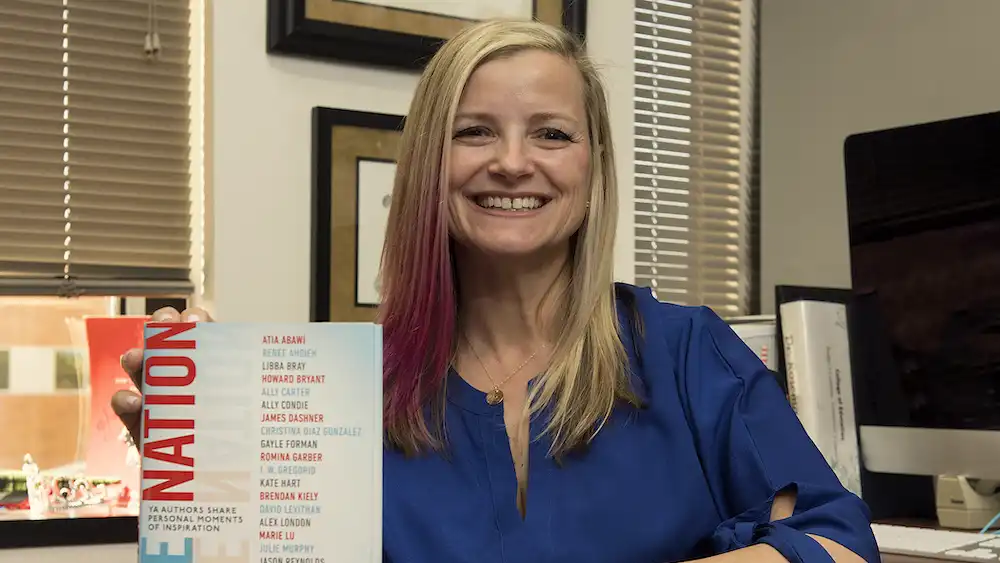 Professor smiling with a book in her hand