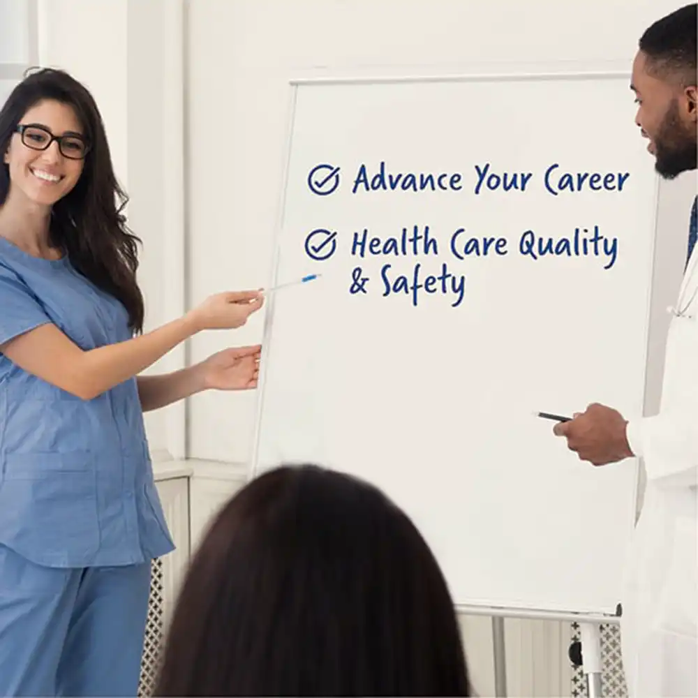 Two women looking at each other, smiling, sitting down, working on an assignment.