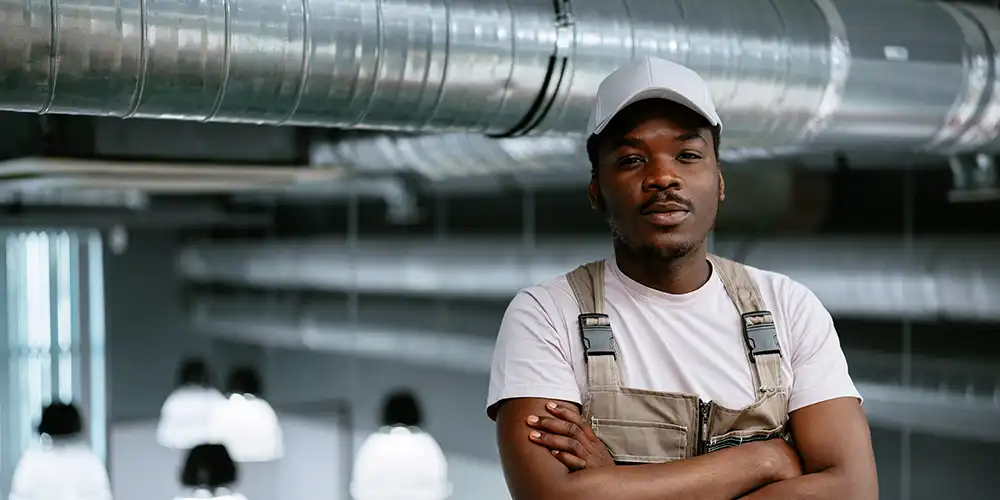 HVAC Student standing in front of indoor HVAC system