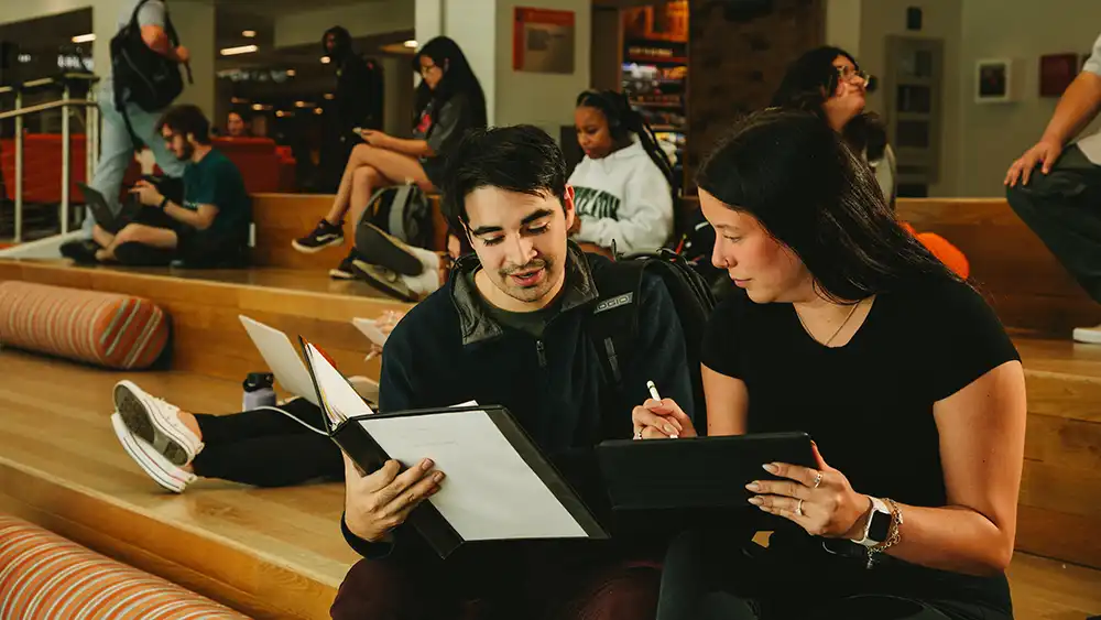 ​​Counselor and student looking at computer in the learning center. 