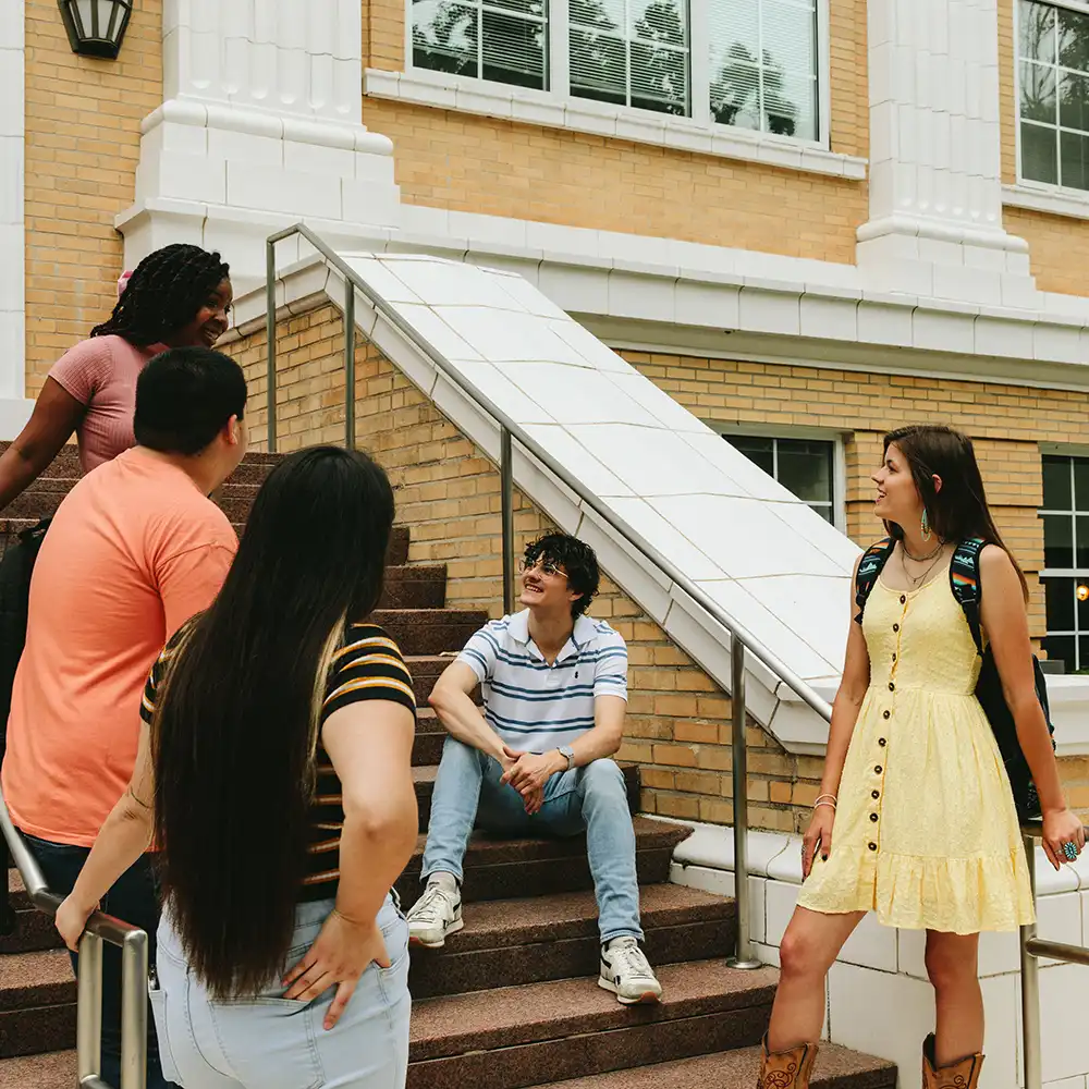 Students meeting on a staircase outside a campus building.