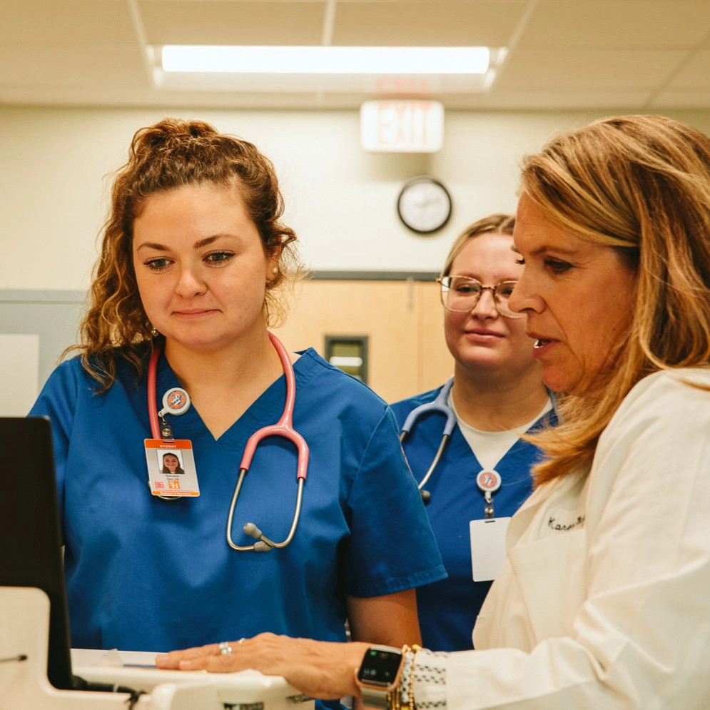 nursing student chats with instructor 