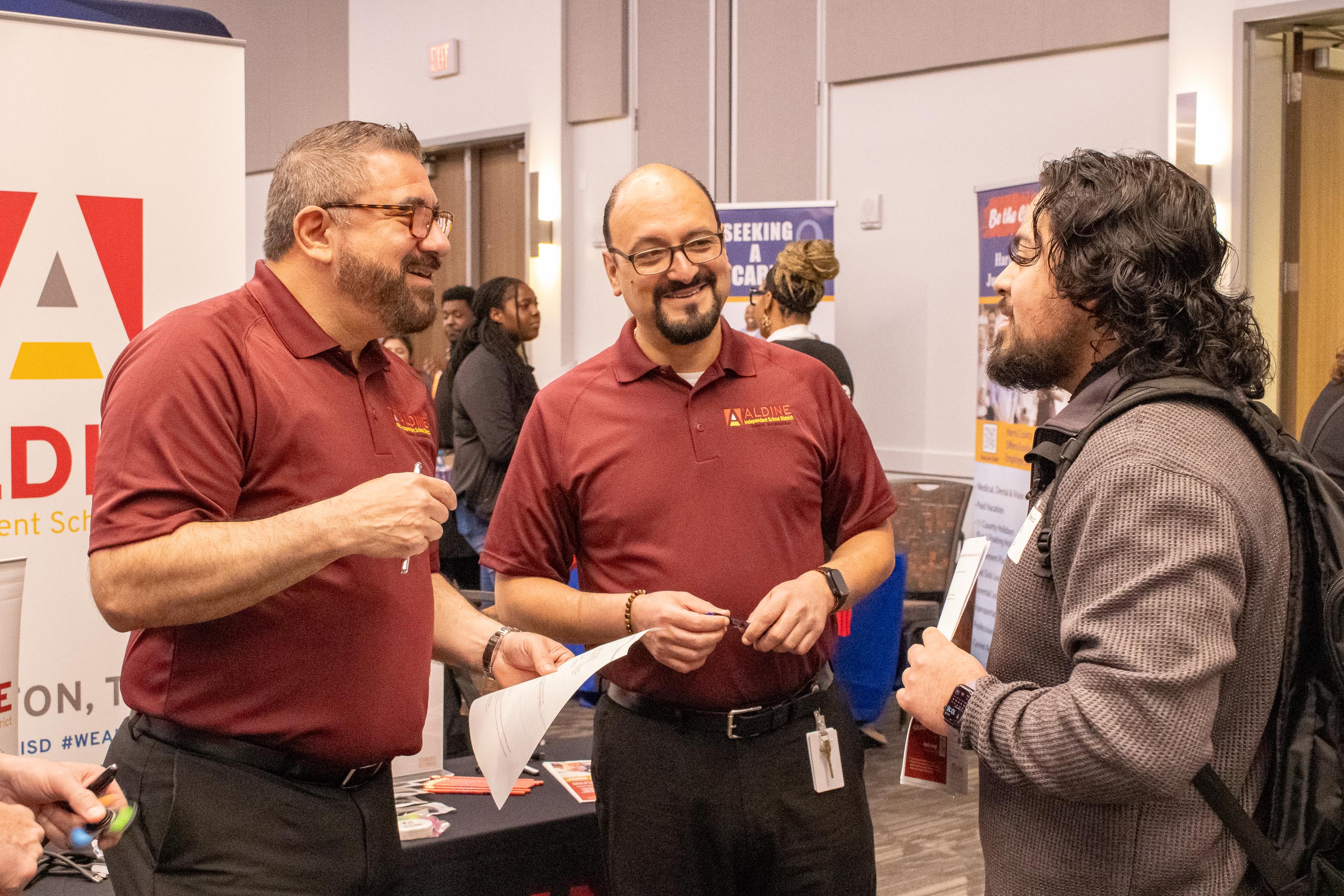 An SHSU College of Education student networking with recruiters from Aldine ISD at a career fair in the Orange Ballroom