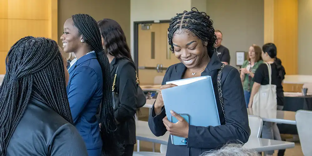 An SHSU student networking with a recruiter at a Nursing Career Fair in The Woodlands Center.