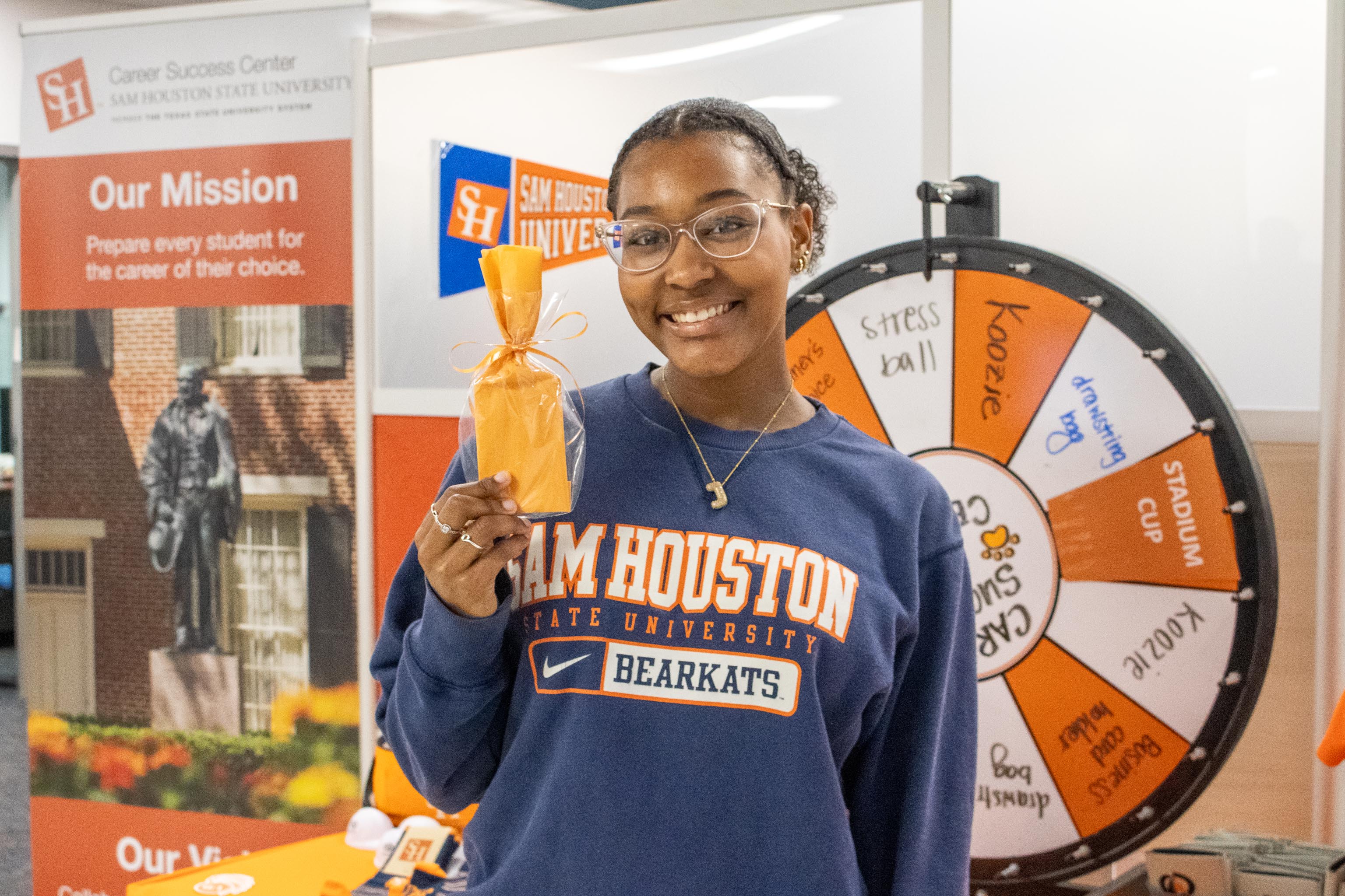 An SHSU student holding a gift card won by attending a Career Success Center event.