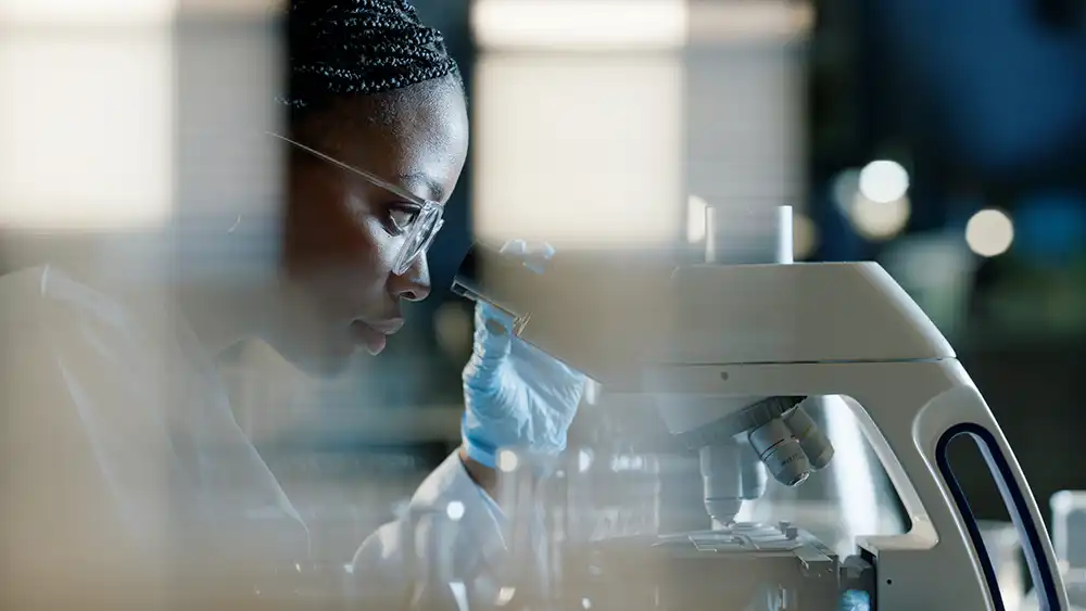 Woman working with a microscope.