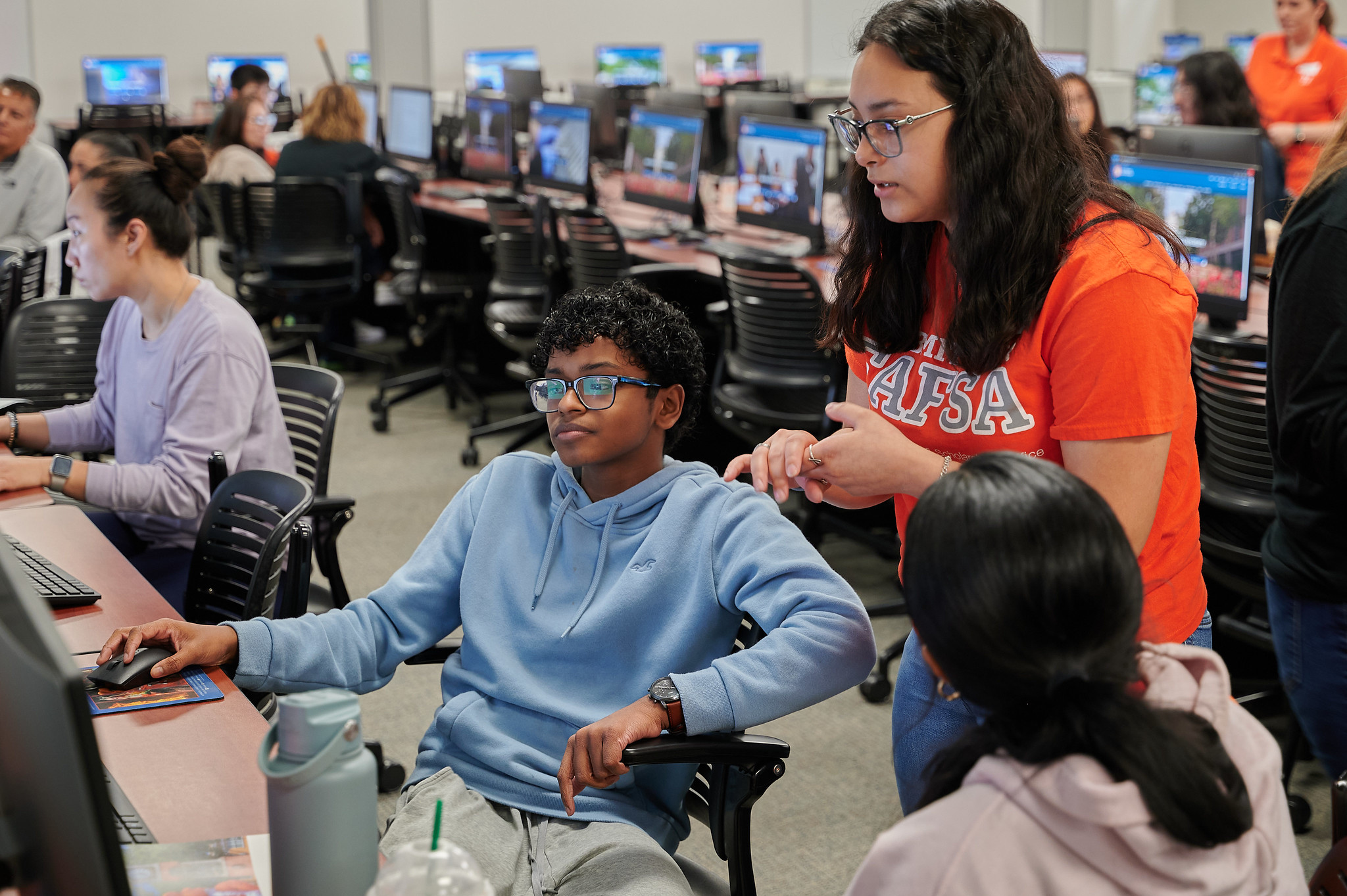 Parents and students inside a computer lab at SHSU being assisted by SHSU faculty.
