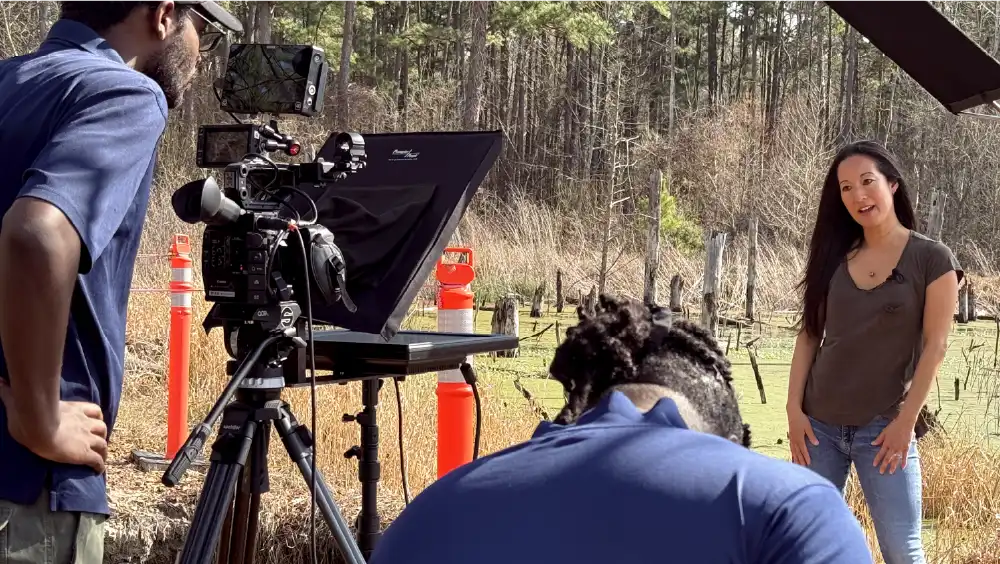 Professor in nature giving lecture in front of camera