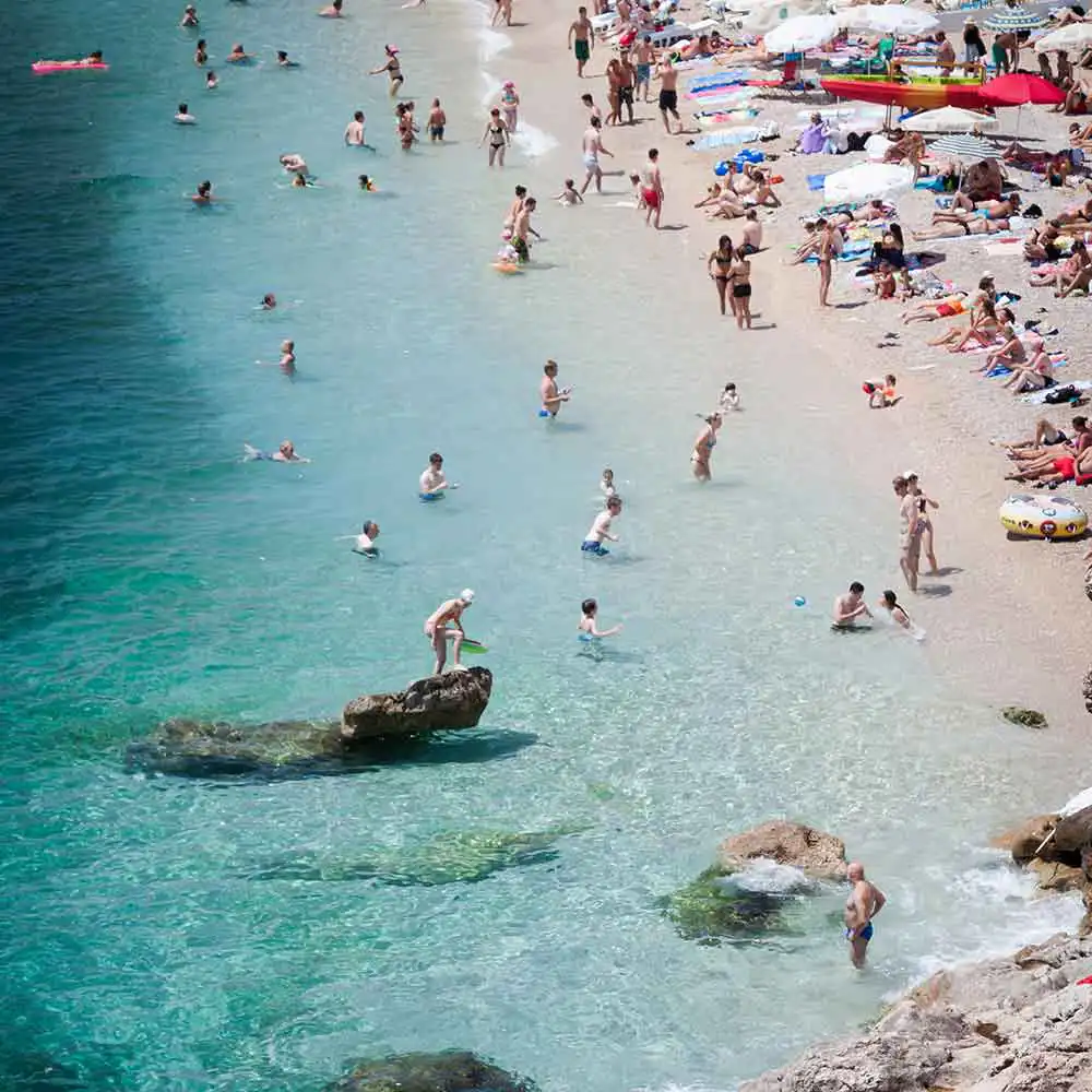 blue ocean and beach with people swimming and being on vacation