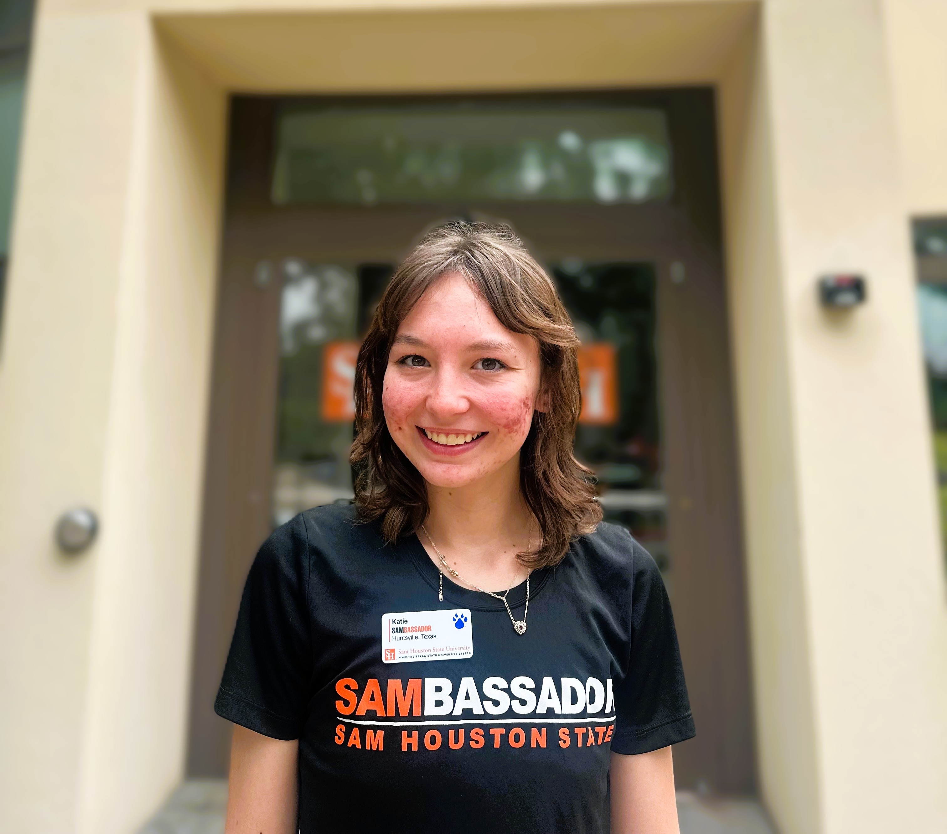 Photo of Katie Renee Culack in front of the Sam Houston State University Visitor Center. 